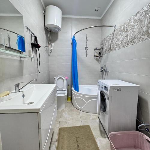 a bathroom with a sink and a washing machine at Атлантис in Chon-Sary-Oy