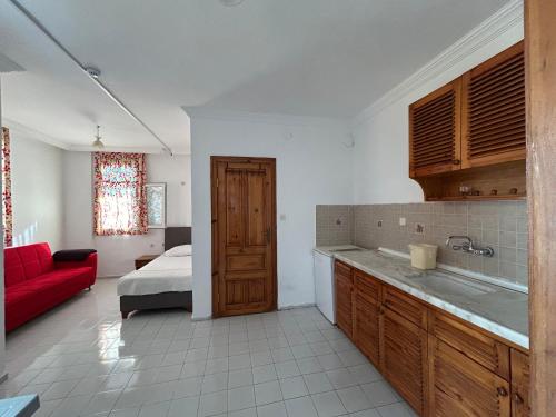 a kitchen with a red couch and a bed in a room at Double Comfort Marmaris in Marmaris