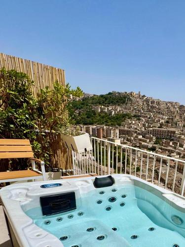 ein Whirlpool auf einem Balkon mit Blick auf die Stadt in der Unterkunft Itria Modica in Modica