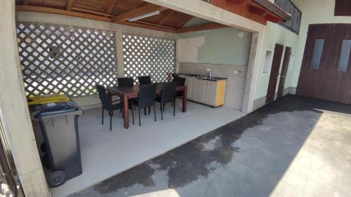 a patio with a table and chairs and a kitchen at Frane House in Knežak