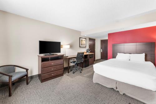 a hotel room with a bed and a desk with a television at River's Edge Convention Center in Columbus