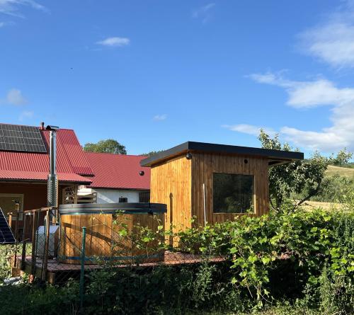 a wooden house in a field next to a building at Agroturystyka Rzepedka - Szarówka in Rzepedż