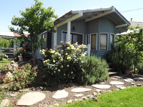 a small blue house with flowers in the front yard at Villa Romantica in Ani'am