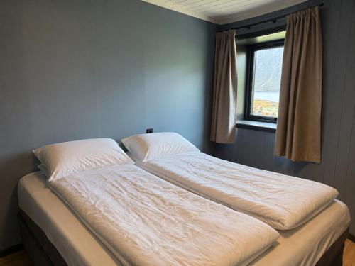 a large bed in a room with a window at Flakstad beach house Silo B in Vareid