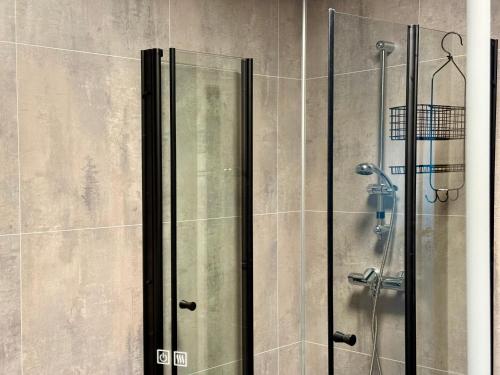 a shower with a glass door in a bathroom at Flakstad beach house Silo B in Vareid