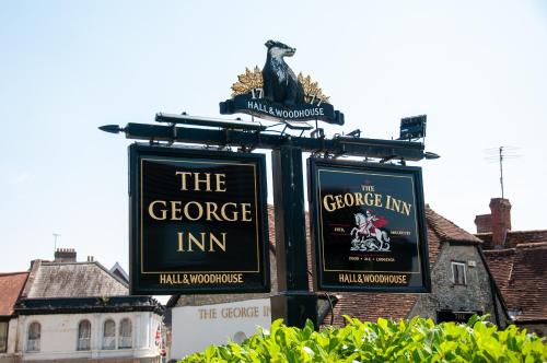 a sign for the goose inn with an eagle on top at George Inn, Mere in Mere