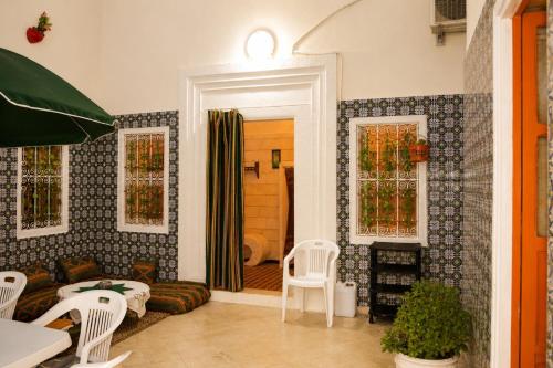 a living room with a couch and two windows at El Hamra Maison Traditionnelle in Mahdia