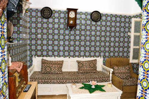 a living room with a couch and a patterned wall at El Hamra Maison Traditionnelle in Mahdia