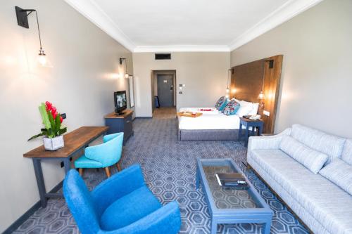 a living room with a couch and blue chairs at Fiesta Royale Hotel in Accra