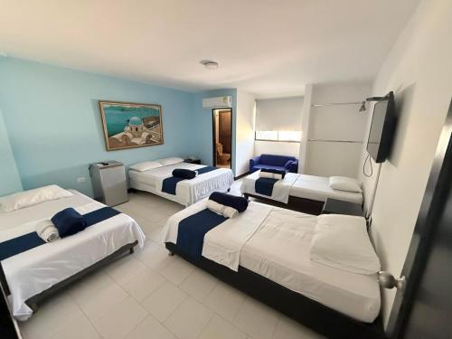 a hotel room with three beds in it at Hotel Exito Barranquilla in Barranquilla