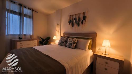 a bedroom with a bed with two lamps and a window at Propiedad San Salvador in Mogán