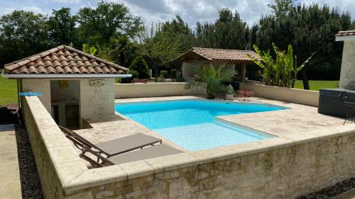 a swimming pool with a stone wall around it at Maison Thierry in Pierre Penot