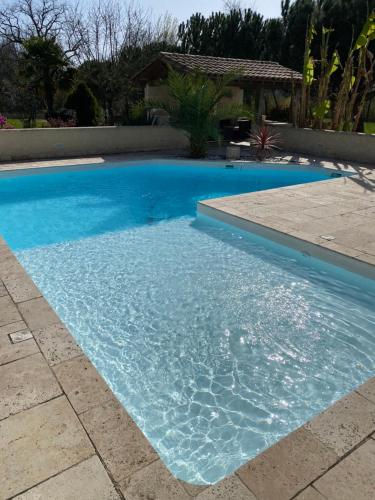a swimming pool with blue water in a yard at Maison Thierry in Pierre Penot