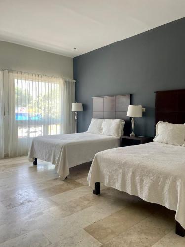 a bedroom with two beds and a window at Grann Hotel in Ciudad Valles