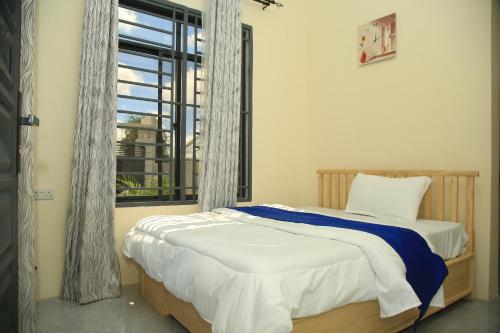 a bedroom with a bed and a large window at Angel homestay hotel in Mikumi