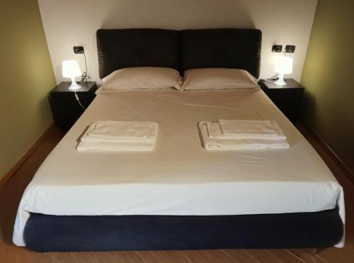a large white bed with two lamps on both sides at Abri Douillet in Saint Marcel