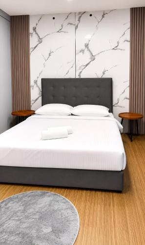 a bedroom with a large bed with white sheets at Neela Homestay in Labuan