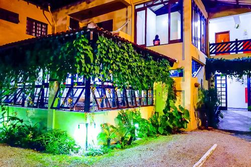 a building with ivy growing on the side of it at VELINN Pousada Recanto dos Tangaras in Juquei