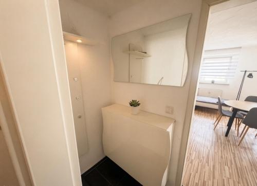 a small white room with a mirror and a table at COMFY Gemütliche Unterkunft 013 in Ditzingen
