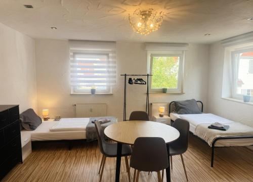 a room with two beds and a table and chairs at COMFY Gemütliche Unterkunft 013 in Ditzingen