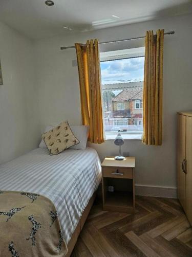 a small bedroom with a bed and a window at Reading Guest House in Reading