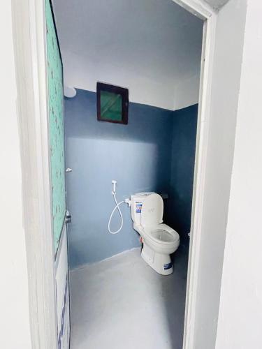 a bathroom with a toilet in a blue wall at Lathu - zen Stay Hotal in Trincomalee