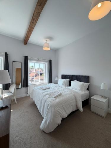 a bedroom with a large white bed and a window at Nova Rooms in Thirsk