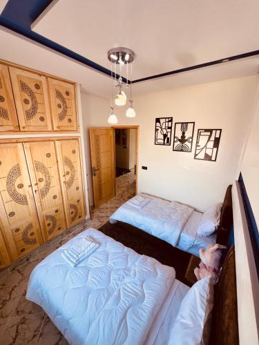 a bedroom with two beds and a chandelier at Merzouga Desert Apartment in Merzouga
