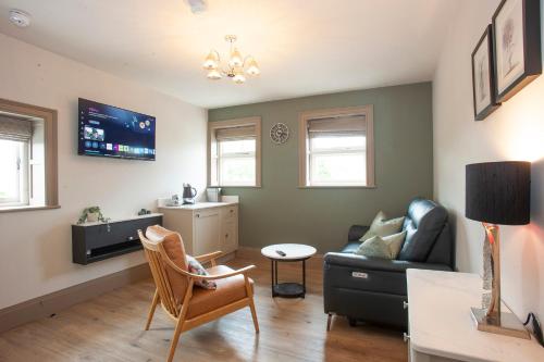 a living room with a couch and a chair at Causeway Squarings in Bushmills