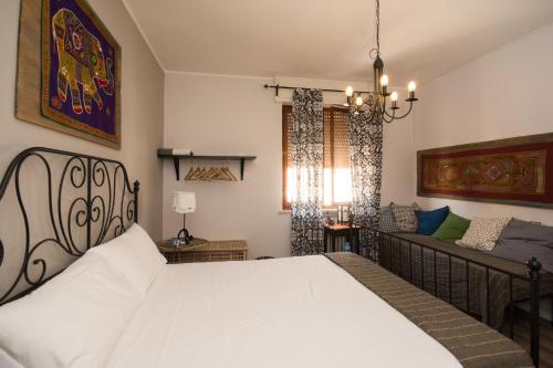 ヴェローナにあるI Girasoli Locazione Turisticaのベッドルーム(白いベッド1台、ソファ付)