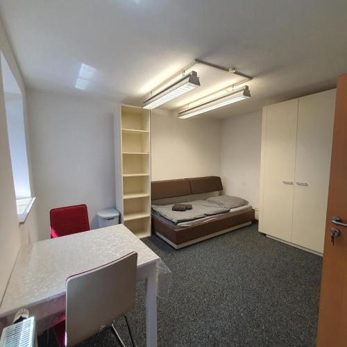 a room with a bed and a desk and a table at Unterkunft in Kreuz 49 in Bayreuth