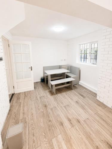 an empty room with a table and a bench at Spacious 5-Bed Entire Home in Sherborne Saint John