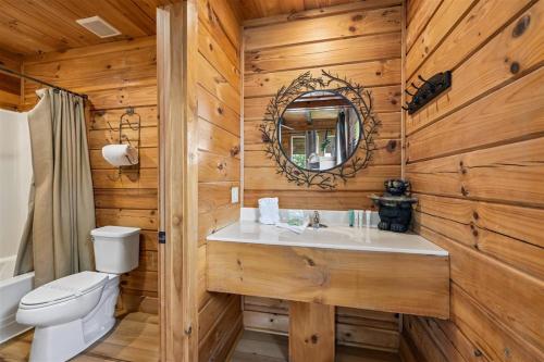 a bathroom with a toilet and a sink in a wooden wall at Mountain Magic #73 by Venture Smoky Mountains in Sevierville