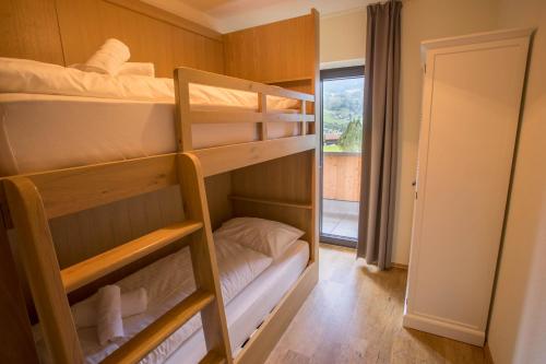 a bunk bed room with two bunk beds and a window at Appart Gastauer in Sankt Gallenkirch