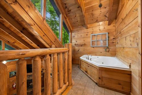a large bathroom with a large tub in a wooden cabin at Once Upon a Time by Venture Smoky Mountains in Sevierville