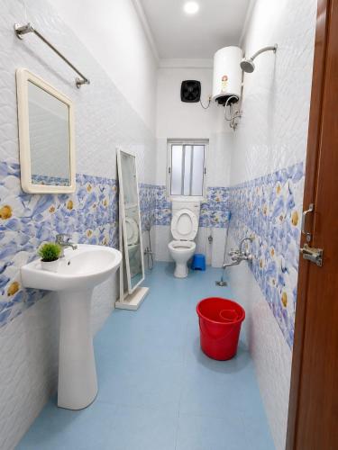 a blue and white bathroom with a sink and a toilet at Cupidtrails Backpacker's Penthouse in Guwahati