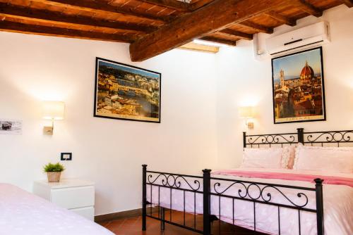 a bedroom with a bed and two pictures on the wall at Max Studios Florence in Florence