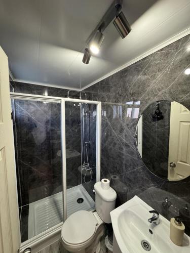 a bathroom with a toilet and a sink and a shower at Casa Miramar in Quellón