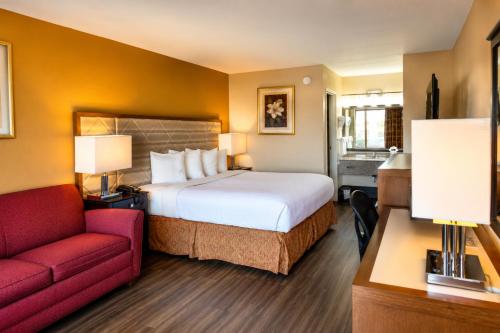 a hotel room with a bed and a red couch at Chattanooga Heritage Inn in Silverdale