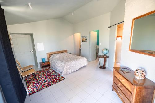 a bedroom with a bed and a dresser and a tv at Escale au marais in Bouin