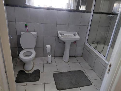 a small bathroom with a toilet and a sink at Ocean River no 1 in Gqeberha