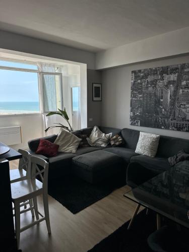 a living room with a black couch and a window at Camera Deluxe in favoloso attico vista mare in Rimini