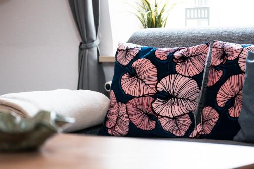a pillow on a couch with a flower pattern at Wiesenweg W10 in Laboe
