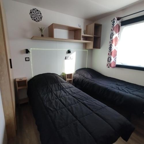 a bedroom with two beds and a window at Terracotta Lodge - Un cocon chaleureux pour des vacances inoubliables in Nibelle