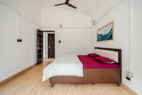 a bedroom with a bed and a ceiling fan at Aravali view Farmhouse in Gurgaon