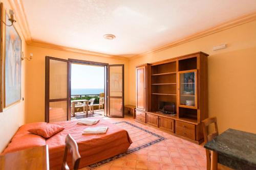 a bedroom with a bed and a table and a window at Bilo 4 in Triscina
