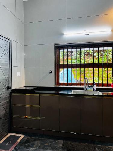 a kitchen with a sink and a window at South Elegance in Tellicherry