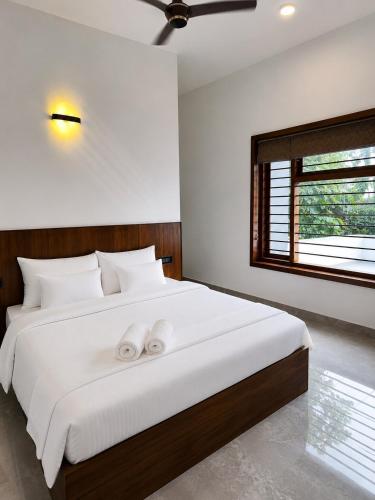 a bedroom with a large bed with two white pillows at South Elegance in Tellicherry