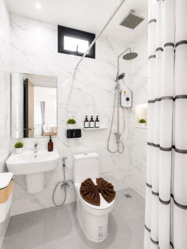 a white bathroom with a toilet and a sink at ต้นจันทร์เรสซิเดนซ์ in Chaweng