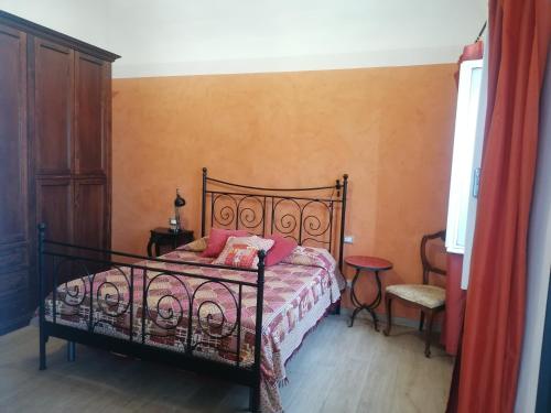 a bedroom with a black bed with pink pillows at Casa Mosaico in Volterra